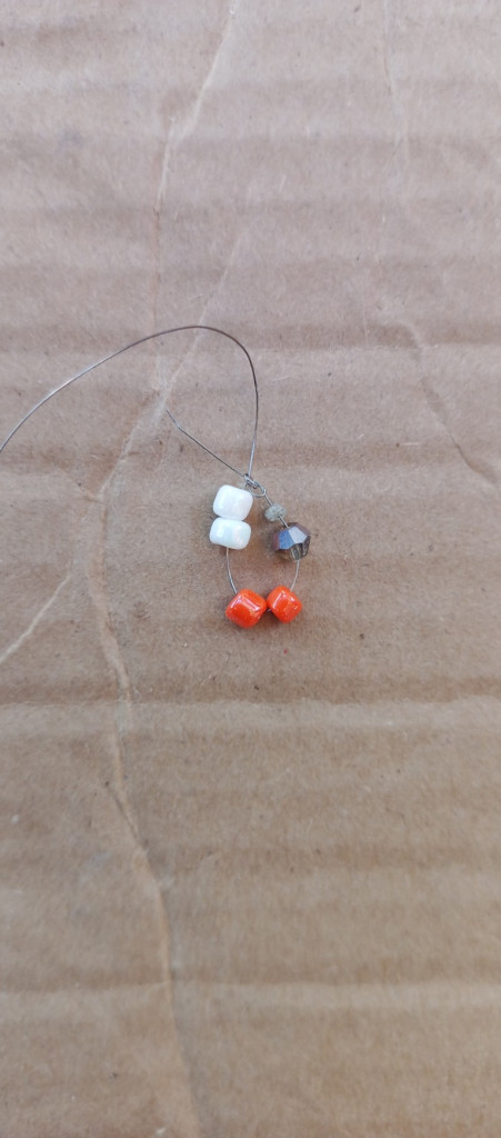 Accessories, Earring, Jewelry, Bead, Necklace, Gemstone, Wood, Food, Sweets, Box, Cardboard, Floor, Flooring, Soil, Fishing Lure, Strap, Pin, Animal, Beak, Bird, Silver, Balloon, Ornament, Electronics, Pendant, Sea Life, Coil, Spiral, Ball, Golf, Golf Ball, Sport, Invertebrate, Seashell, Coin, Money, Agate, Fish, Carton, Produce